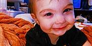 Mila Grace joined the competition — help win amazing prizes! baby, smiling, face, child, blanket, orange, cozy, indoors, cute, portrait, happy, young, person, toddler, clothing, bedroom, soft, expression, closeup, warm
