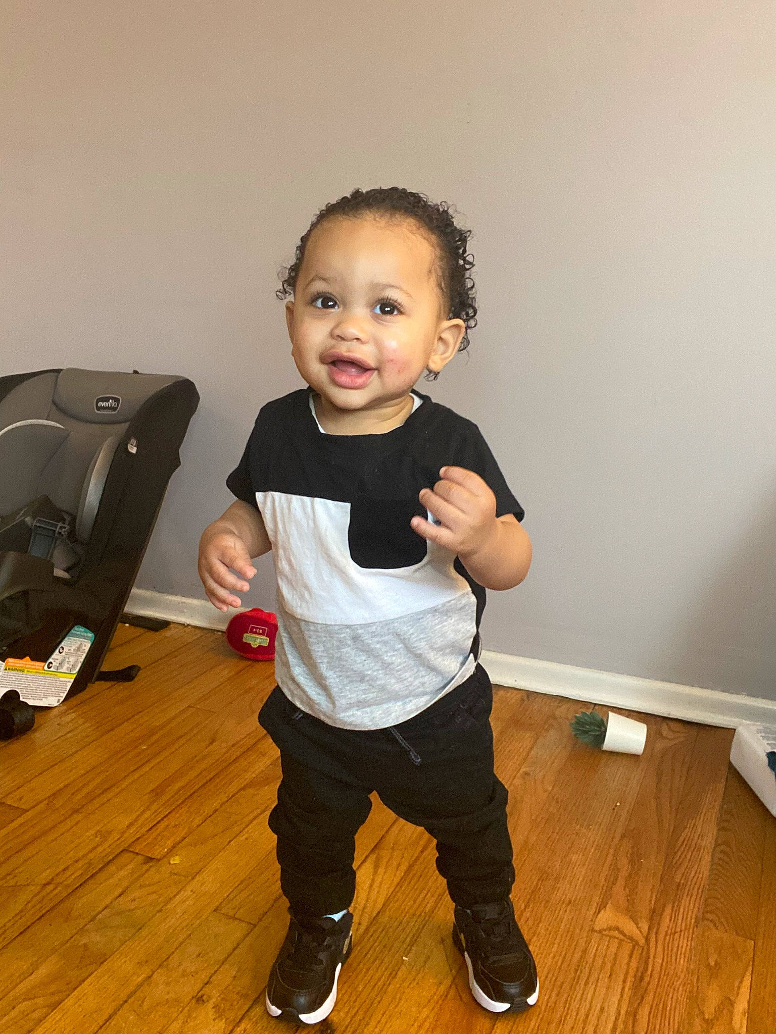 Josiah is registered to the contest to win money with this photo: baby_toddler_clothing, cheek, child, eye, face, flash_photography, floor, flooring, fun, gesture, happy, hardwood, person, shoe, sleeve, smile, sweatpant, toddler, varnish, wood