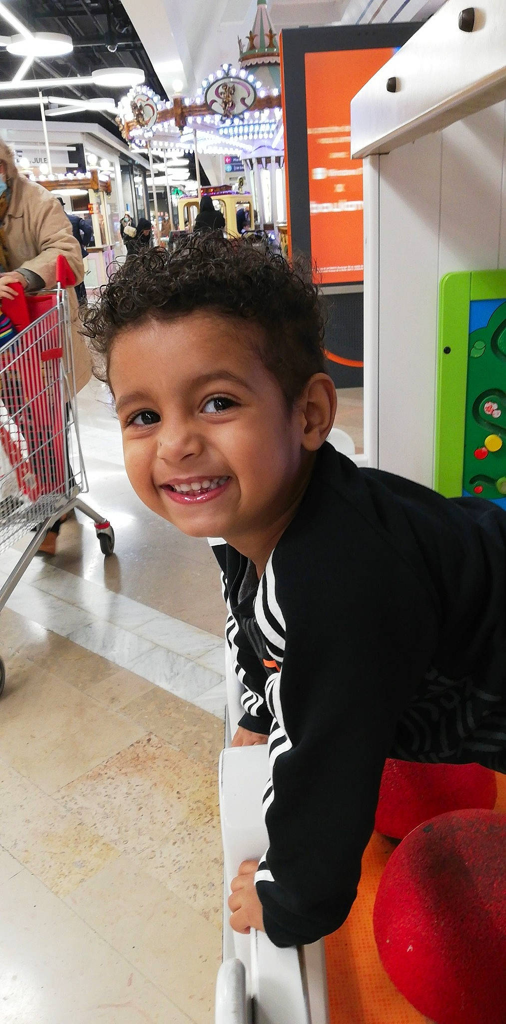 Nahil a rejoint le concours — aidez-le/la à gagner de superbes lots ! bag, cart, child, event, flooring, fun, happy, joy, leisure, luggage_and_bags, machine, person, recreation, retail, shopping, shopping_cart, smile, t_shirt, tire, toddler