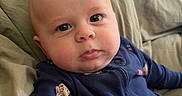Landen is registered to the contest to win money with this photo: baby, infant, face, portrait, child, blue_onesie, baseball_patches, blanket, indoors, cute, expression, young_child, person, real_photo, closeup, sitting, soft_lighting, casual, comfortable, home