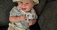 Landen is registered to the contest to win money with this photo: baby, bib, child, clothing, couch, cute, face, foot, hand, happy, hat, indoor, infant, pacifier, person, shorts, sitting, smiling, texture, tshirt