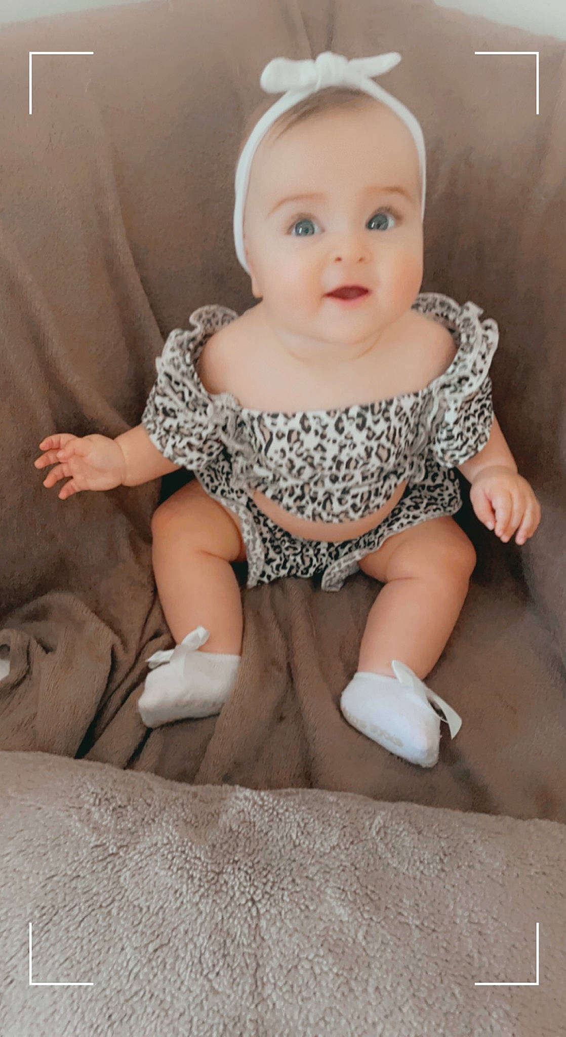 Lia participe au concours pour gagner de l'argent avec cette photo : baby, baby_toddler_clothing, cheek, child, face, finger, flooring, head, human_body, human_leg, iris, leg, lip, pattern, person, sitting, skin, sleeve, smile, surprise