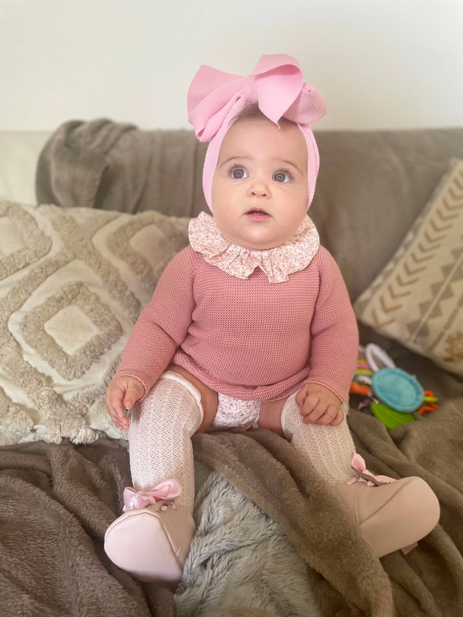 Lia participe au concours pour gagner de l'argent avec cette photo : arm, baby, baby_toddler_clothing, cap, cheek, child, comfort, costume_hat, couch, eye, face, head, lip, magenta, pattern, person, pink, skin, sleeve, textile