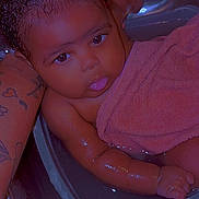 Kira joined the competition — help win amazing prizes! baby, child, towel, bath, water, arm, tattoo, skin, hand, face, tongue, curly_hair, bathtub, cute, playful, indoors, person, infant, wet, support