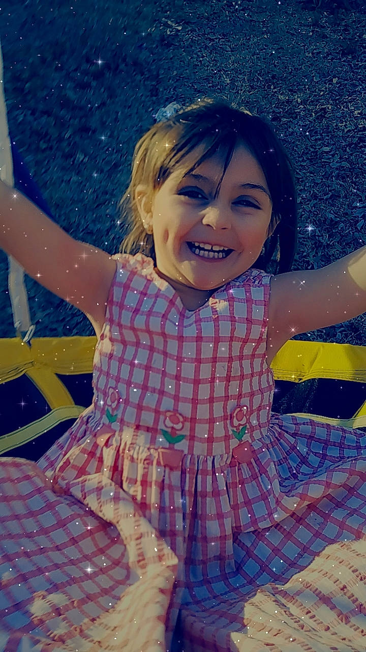 Gabriella is registered to the contest to win money with this photo: baby_toddler_clothing, child, dress, eye, face, facial_expression, finger, fun, gesture, hairstyle, happy, human_body, joy, people_in_nature, person, pink, skin, smile, standing, thigh