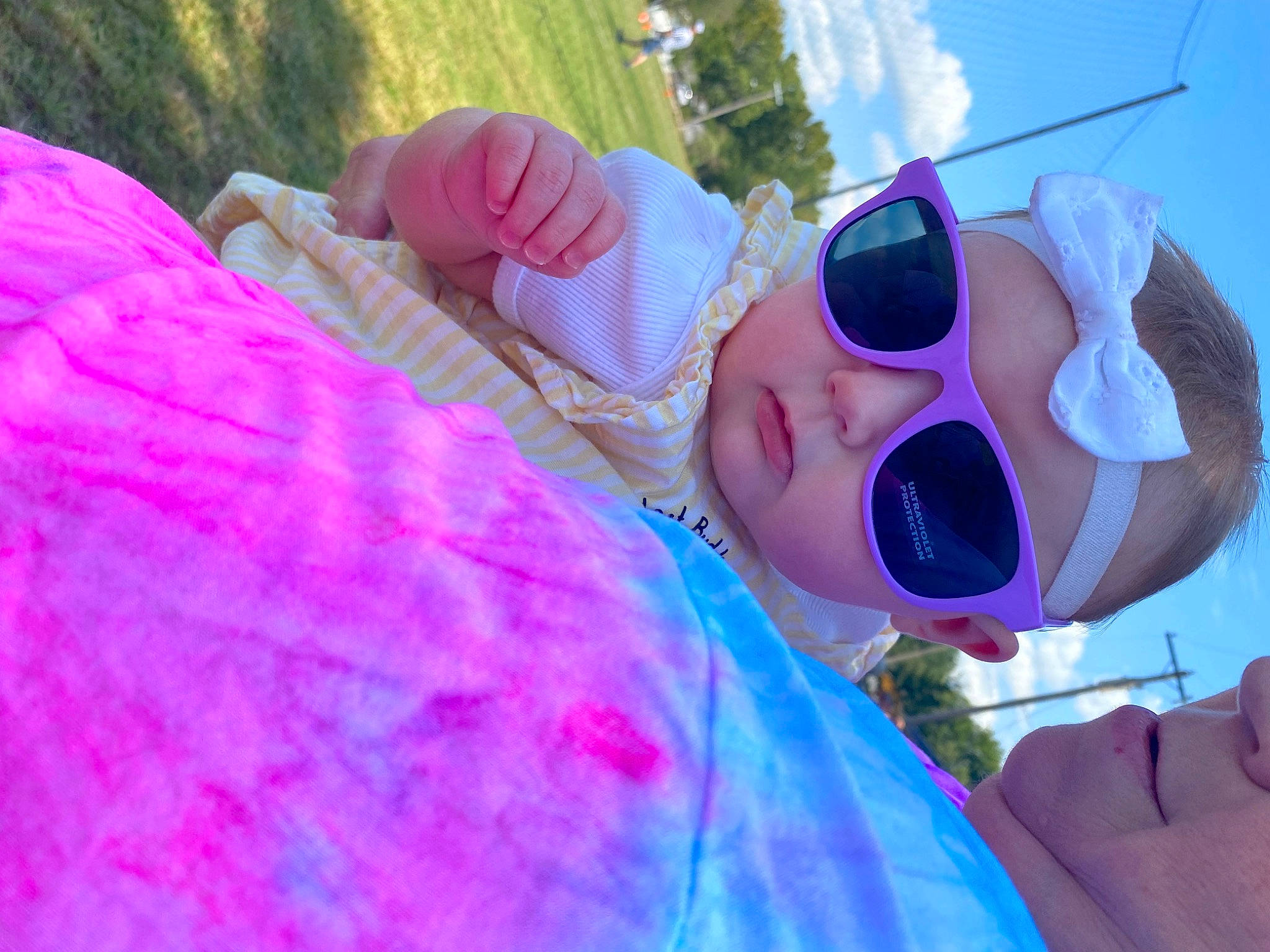Madelyn is registered to the contest to win money with this photo: child, electric_blue, event, eyewear, fun, glasses, goggles, grass, happy, headwear, leisure, magenta, person, personal_protective_equipment, pink, plant, purple, recreation, sky, sunglasses