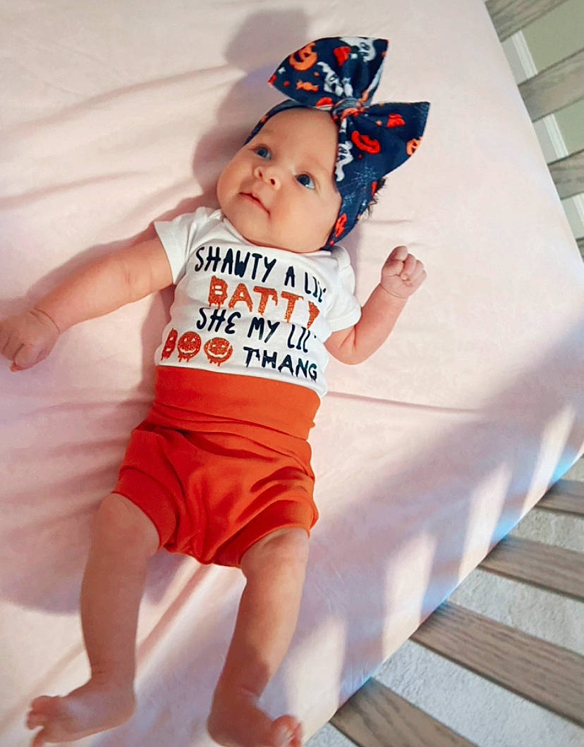 Audriella joined the competition — help win amazing prizes! baby, baby_bloomers, baby_toddler_clothing, child, clothing, headwear, orange, pattern, person, product, sleeve, t_shirt, toddler