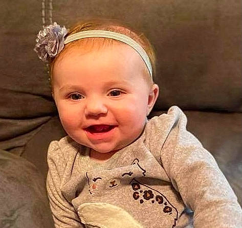 Kinzlee is registered to the contest to win money with this photo: baby, baby_toddler_clothing, brown_hair, cheek, child, comfort, ear, eye, eyelash, face, fashion_accessory, happy, headband, headgear, headpiece, jewellery, person, skin, sleeve, smile