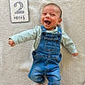 baby, infant, smiling, denim_overalls, blue_clothing, lying_down, blanket, soft_texture, happy, face, head, person, child, cute, two_months, sign, hand, foot, portrait, indoors