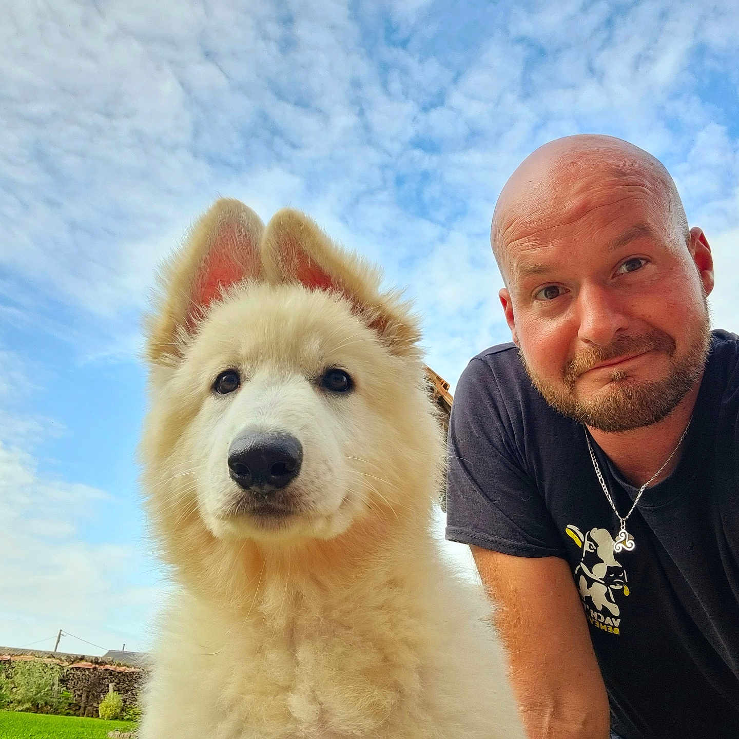 Valoue participe au concours pour gagner de l'argent avec cette photo : dog, person, outdoor, sky, cloud, grass, smile, beard, bald, ear, fur, necklace, tshirt, greenery, yard, daylight, portrait, cute, animal, pet