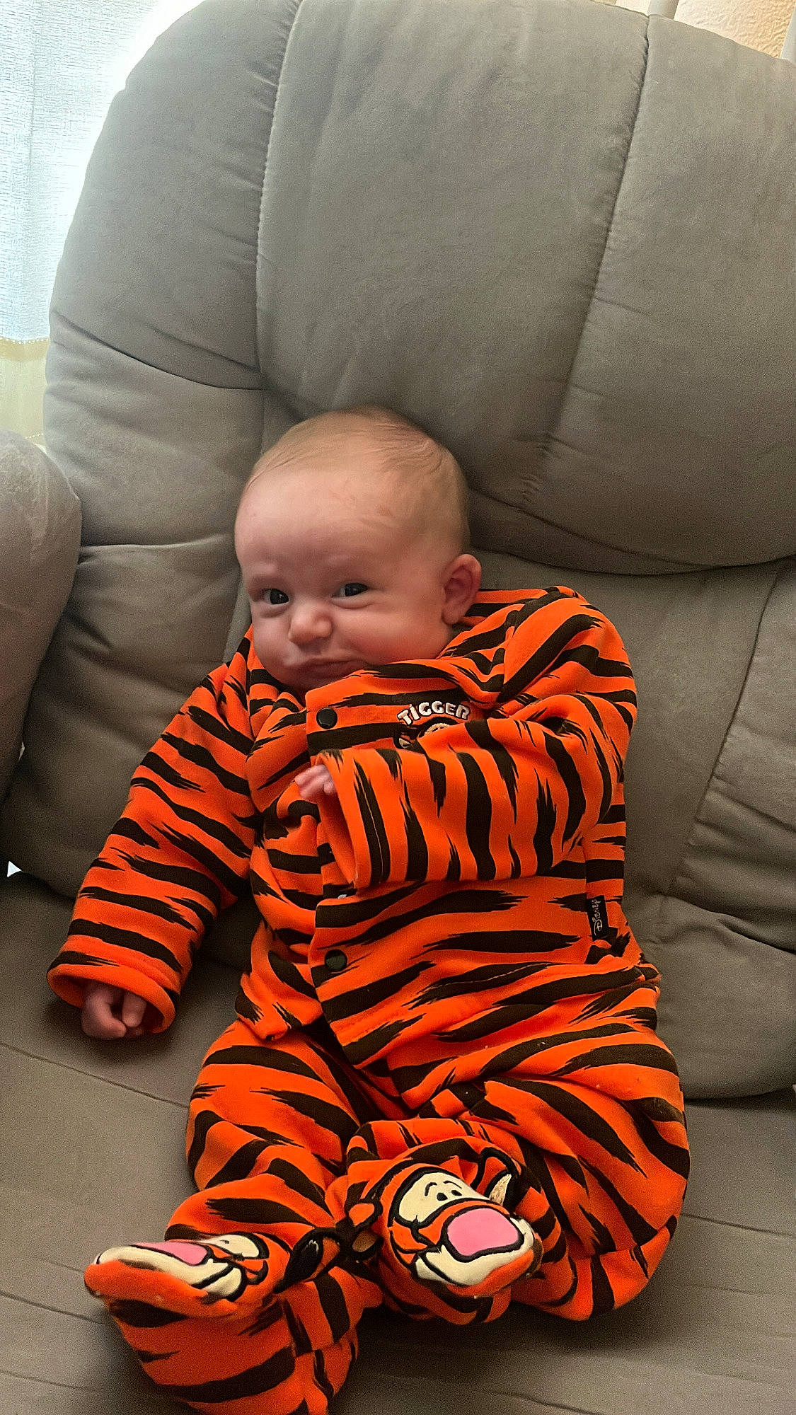 Owen is registered to the contest to win money with this photo: baby, baby_toddler_clothing, car_seat, carmine, carpet, chair, cheek, child, comfort, couch, flooring, fun, head, human_leg, orange, person, room, sitting, sleeve, toddler