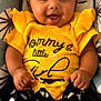 Aliyah a rejoint le concours — aidez-le/la à gagner de superbes lots ! baby, black_hair, bow, cheerful, child, cute, face, hands, happy, headband, heart_pattern, indoors, infant, patterned_background, portrait, shorts, sitting, skin, smiling, yellow_clothing