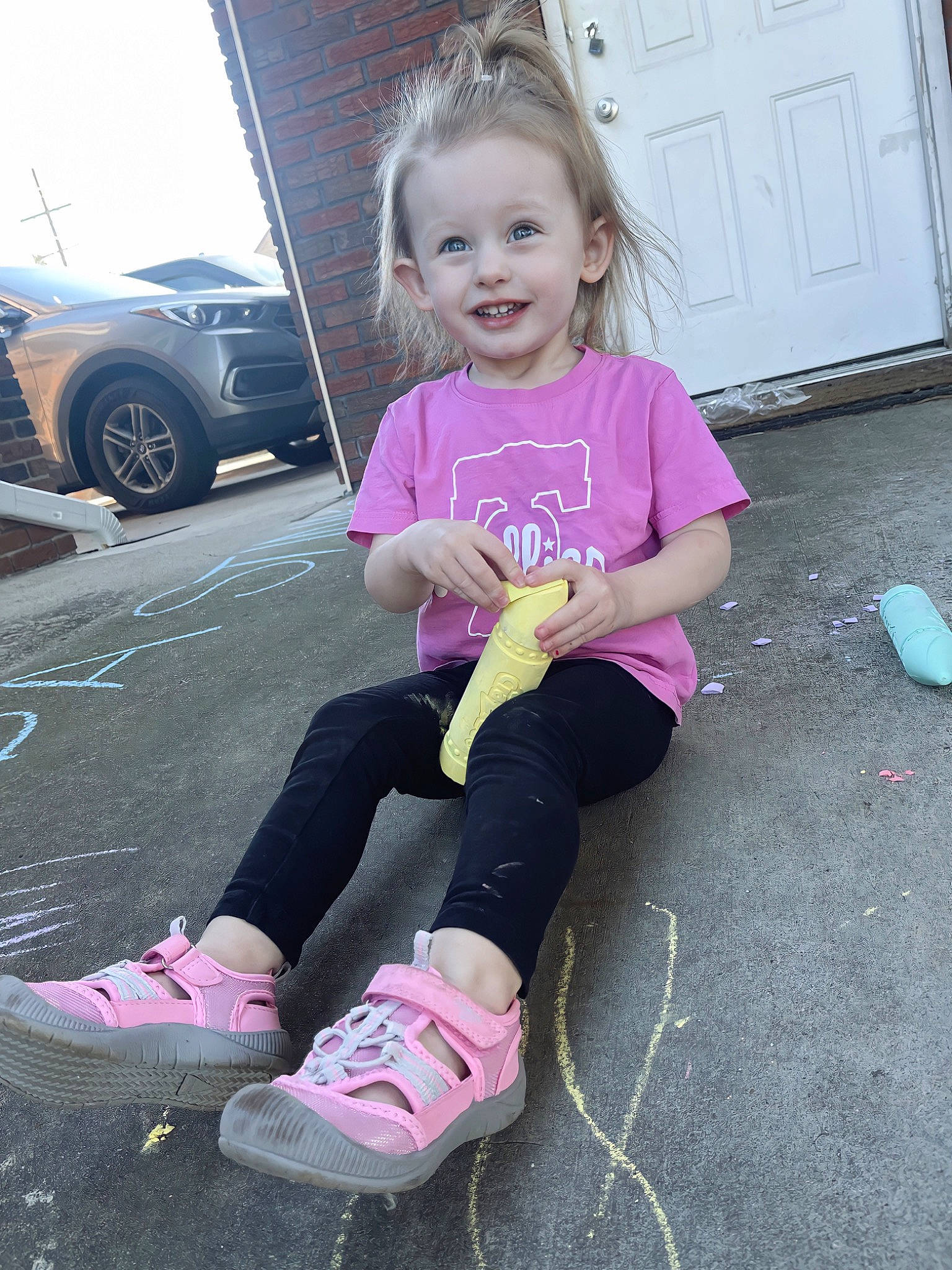 Hadlee is registered to the contest to win money with this photo: automotive_tire, car, child, cool, dress, face, footwear, hair, hairstyle, head, joy, knee, motor_vehicle, person, pink, smile, standing, street_fashion, tire, toddler