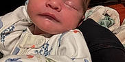 Colton is registered to the contest to win money with this photo: baby, sleeping, newborn, infant, onesie, floral, arm, blanket, pattern, indoor, closeup, face, peaceful, child, soft, cute, young, person, resting, cozy