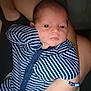 Colton is registered to the contest to win money with this photo: baby, newborn, striped_clothing, onesie, arm, bracelet, beads, infant, person, holding, closeup, face, skin, adult_arm, sleepwear, cute, portrait, indoors, soft_lighting, calm