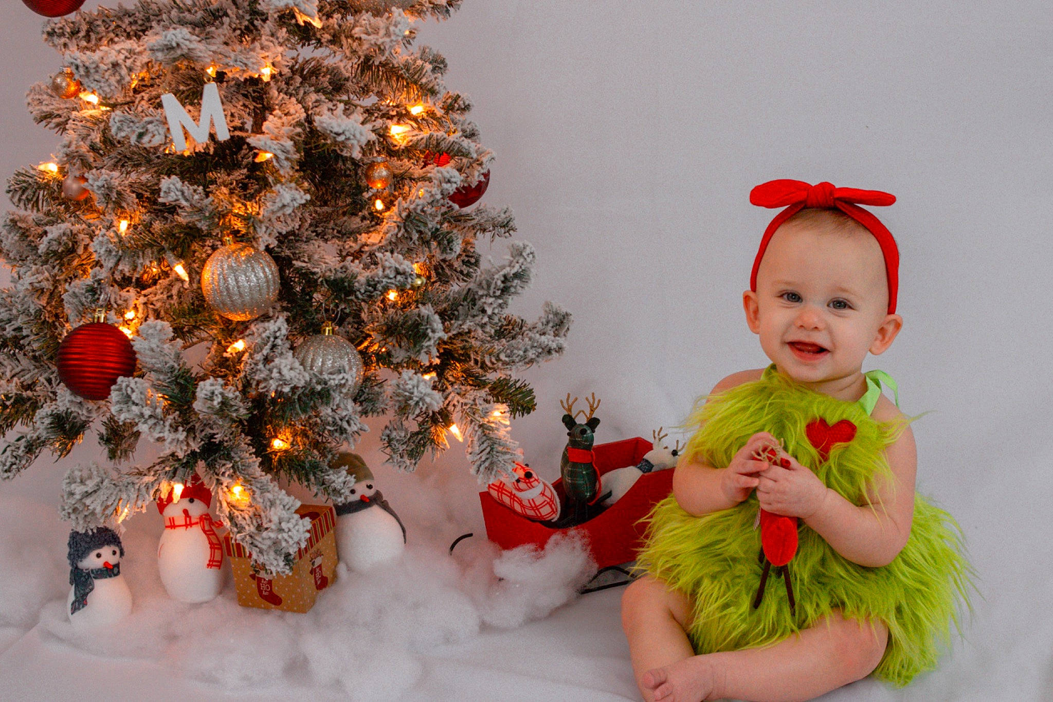 Milani is registered to the contest to win money with this photo: baby, baby_toddler_clothing, christmas, christmas_decoration, christmas_eve, christmas_ornament, christmas_tree, event, evergreen, happy, holiday, holiday_ornament, human_body, joy, leaf, ornament, person, plant, red, smile