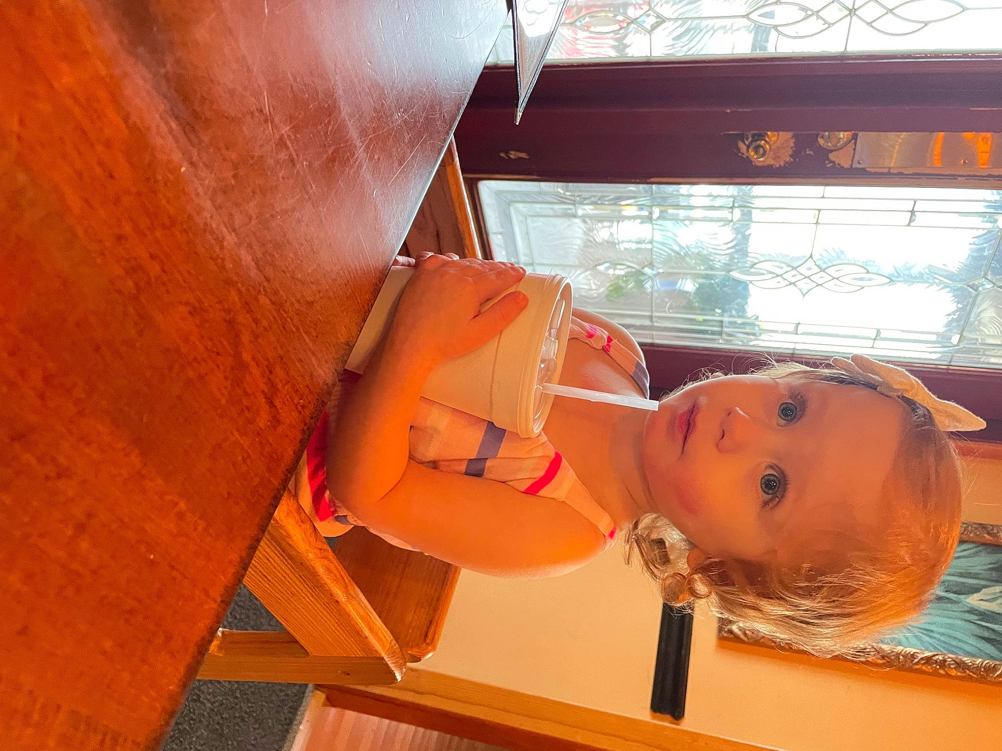 Carmella is registered to the contest to win money with this photo: abdomen, bathing, chest, child, eyewear, flooring, fun, human_leg, leisure, orange, peach, person, personal_protective_equipment, room, swimming_pool, swimwear, toddler, wood