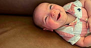 Maverick joined the competition — help win amazing prizes! baby, smiling, happy, infant, portrait, face, child, pink_shirt, striped_clothing, couch, leather_surface, closeup, cute, young_child, skin, head, eyes, mouth, expression, relaxed