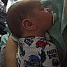 arm, baby, bed, blanket, child, close_up, comfort, face, head, indoor, infant, onesie, pacifier, patterned_clothing, peaceful, person, resting, sleeping, soft_lighting, tattoo