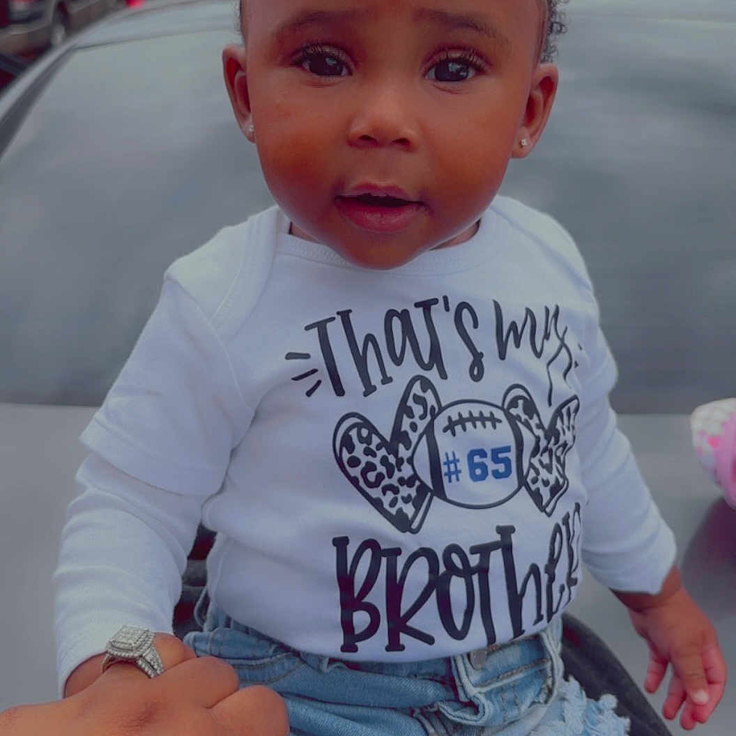 Nyema joined the competition — help win amazing prizes! car, car_hood, casual_clothing, child, closeup, curious_expression, curly_hair, daylight, denim_jeans, girl, hand_with_ring, holding_hand, outdoor, person, portrait, puff_ponytails, ripped_jeans, text_on_shirt, toddler, white_shirt