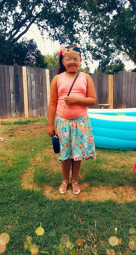 Mea is registered to the contest to win money with this photo: abdomen, barefoot, chest, child, eyewear, fence, fun, grass, happy, headwear, human_leg, leisure, navel, people_in_nature, person, pink, sandal, summer, thigh, tree