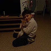 Jean-Gabriel a rejoint le concours — aidez-le/la à gagner de superbes lots ! child, boy, cat, indoor, carpet, floor, furniture, smile, hug, pet, home, television, plant, shoe, casual_clothing, radiator, chair, toy, cozy, dim_light