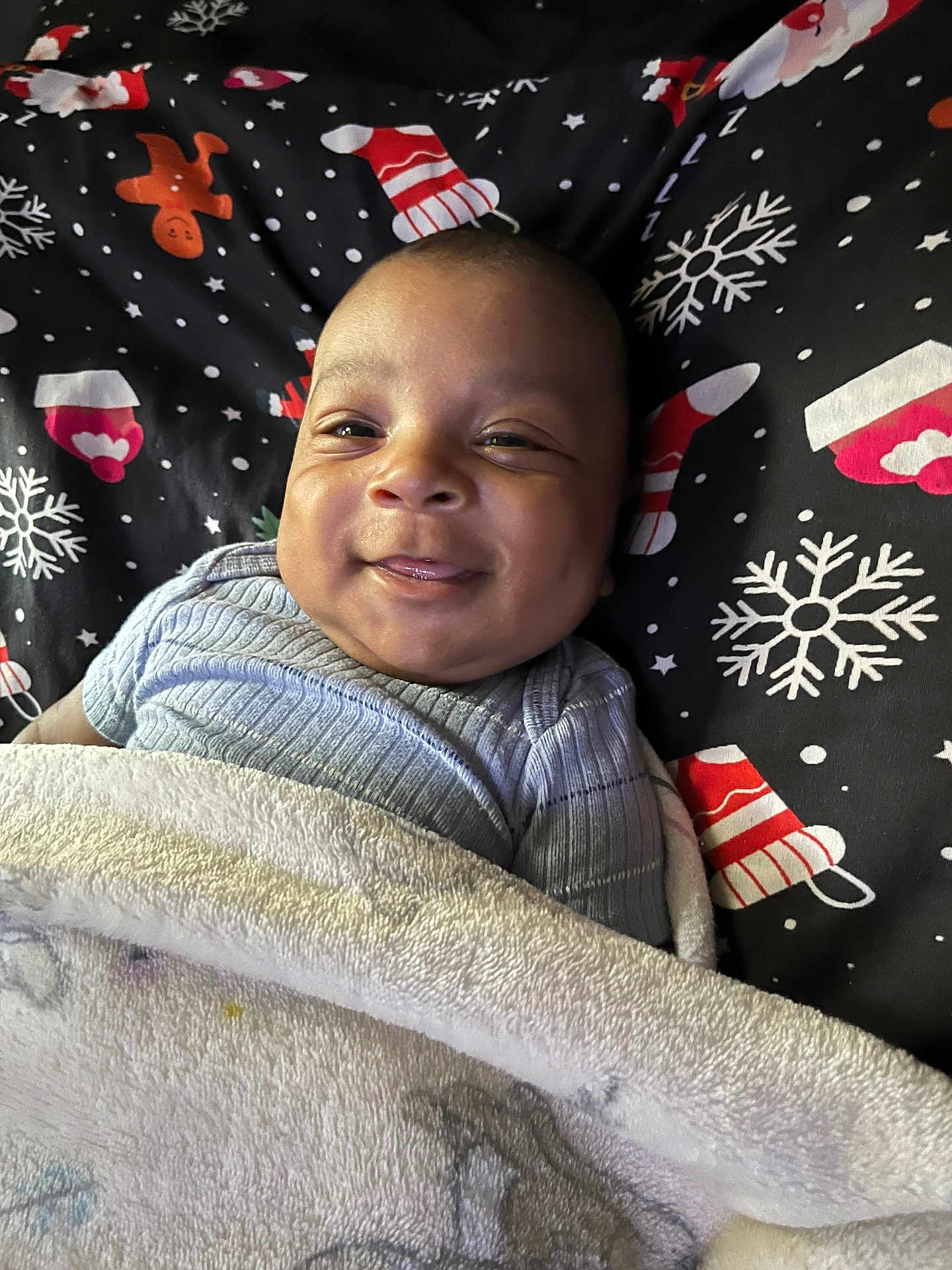 Zomani joined the competition — help win amazing prizes! baby, smile, blanket, cozy, infant, face, lying_down, festive, holiday, snowflake, gingerbread_man, mittens, clothing, cute, happy, portrait, child, indoors, soft, warm