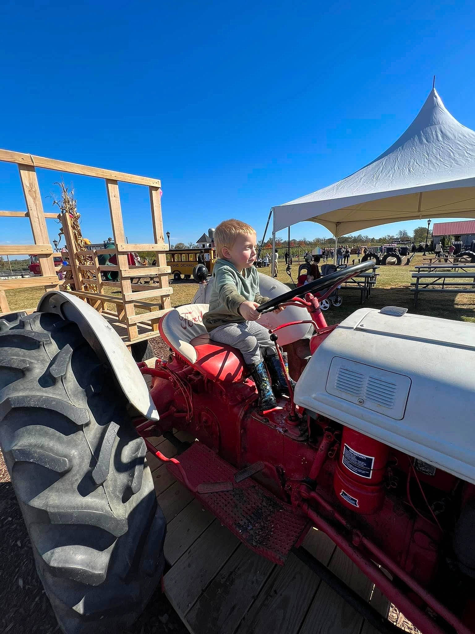 Easton is registered to the contest to win money with this photo: agricultural_machinery, auto_part, automotive_design, automotive_exterior, automotive_tire, automotive_wheel_system, bumper, engineering, fender, machine, mode_of_transport, motor_vehicle, person, rolling, sky, tent, tire, tractor, tread, vehicle