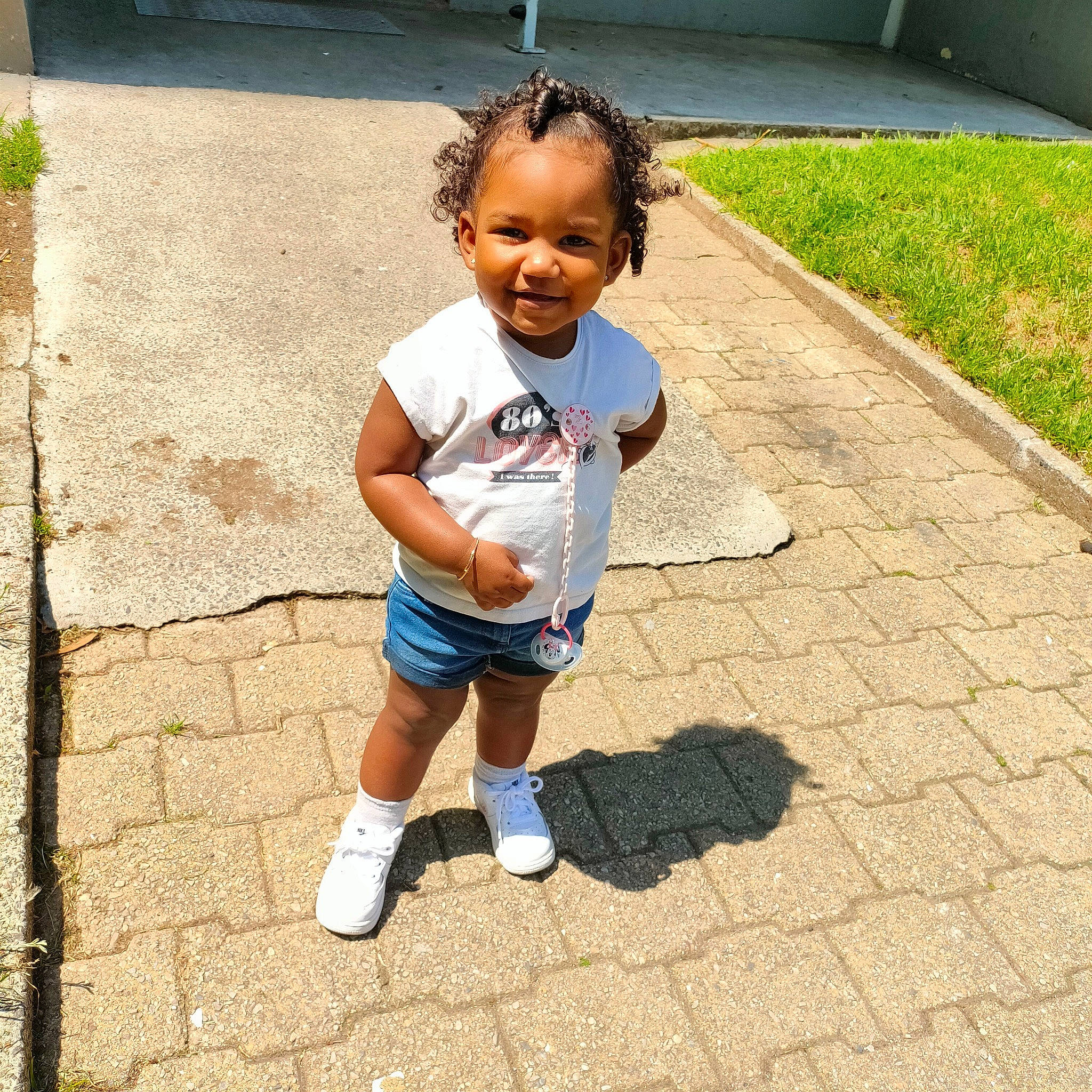 Swaina participe au concours pour gagner de l'argent avec cette photo : asphalt, baby_toddler_clothing, child, eye, face, facial_expression, flooring, grass, hairstyle, happy, head, joy, leisure, person, road_surface, shorts, sidewalk, sleeve, smile, t_shirt