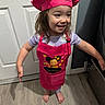 Savannah joined the competition — help win amazing prizes! child, girl, chef_hat, apron, smile, barefoot, indoor, wood_floor, door, happy, clothing, person, cute, playful, standing, long_hair, purple_shirt, kitchen, flooring, home
