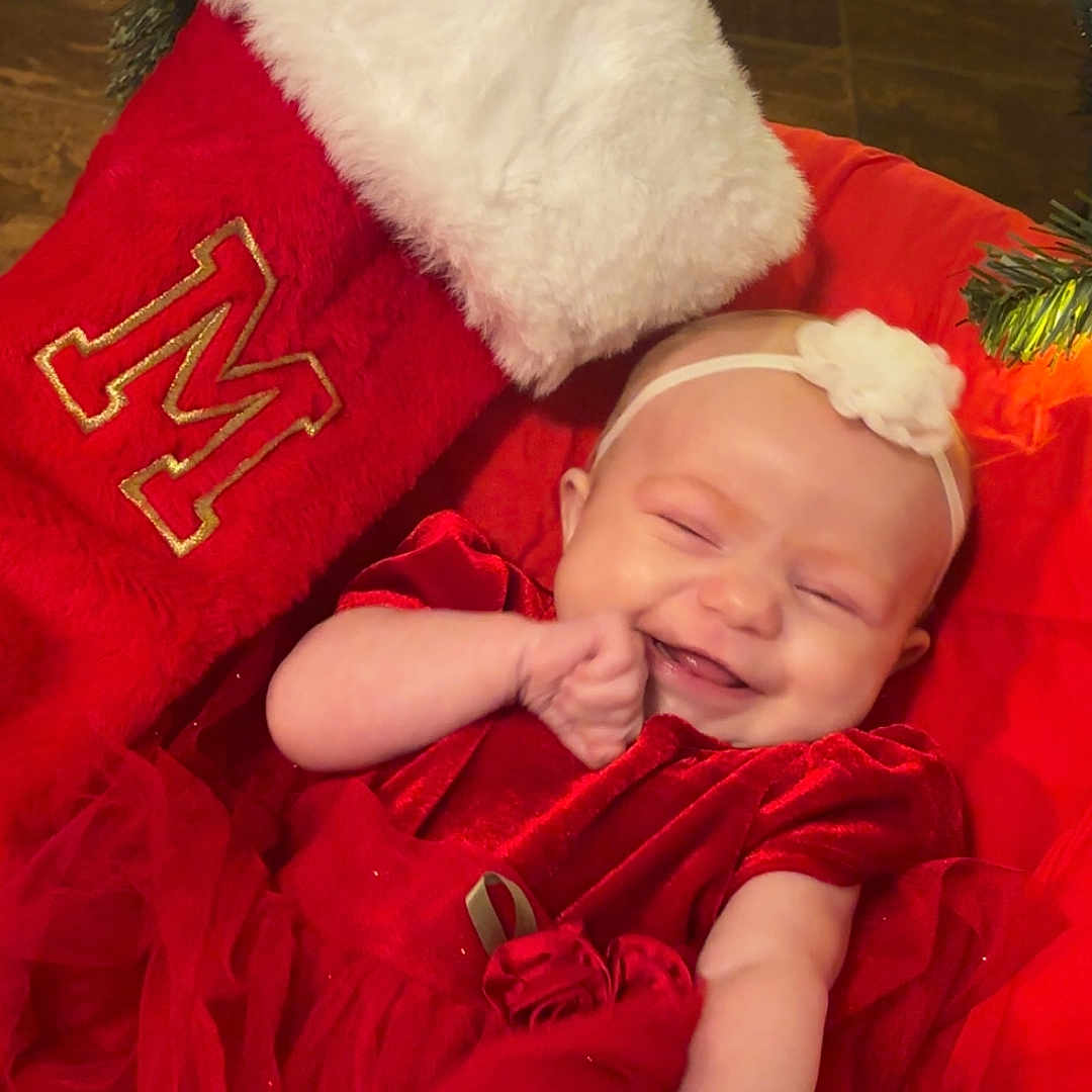 Mary Ann is registered to the contest to win money with this photo: baby, celebration, child, christmas_stocking, christmas_tree, cute, decoration, festive, happy, headband, holiday, holiday_clothing, indoor, infant, joy, person, red_dress, seasonal, smile, smiling