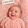 baby, infant, child, smiling, portrait, indoors, pink, blanket, fluffy, onesie, giraffe, clothing, face, eyes, mouth, happy, lying_down, close_up, text_overlay, photography