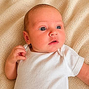 Lilly-Grace joined the competition — help win amazing prizes! baby, infant, newborn, white_onesie, knitted_blanket, beige_blanket, lying_down, curious_expression, wide_eyes, soft_lighting, cute, child, portrait, skin, head, hand, small_fingers, indoors, cozy, soft_texture