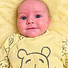 baby, infant, child, portrait, lying_down, yellow_blanket, yellow_clothing, onesie, teddy_bear, bear_print, fluffy_blanket, close_up, face, eyes, wide_eyed, indoors, cozy, cute, photography, safe