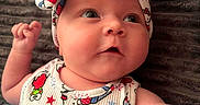 Cali joined the competition — help win amazing prizes! apparel, arm, baby, blanket, child, closeup, colorful, cute, expression, face, headband, hello_kitty, indoors, infant, lying_down, patterned_clothing, popsicle, portrait, skin, soft_texture