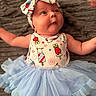 Cali joined the competition — help win amazing prizes! baby, infant, headband, tutu, dress, blue, cute, cartoon, character, face, skin, arms, blanket, texture, clothing, lying_down, curious, child, portrait, indoors