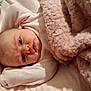Liliana is registered to the contest to win money with this photo: baby, infant, blanket, pink_blanket, bed, soft, cozy, face, expression, curious, clothing, sleepwear, resting, lying_down, indoor, child, newborn, portrait, skin, head