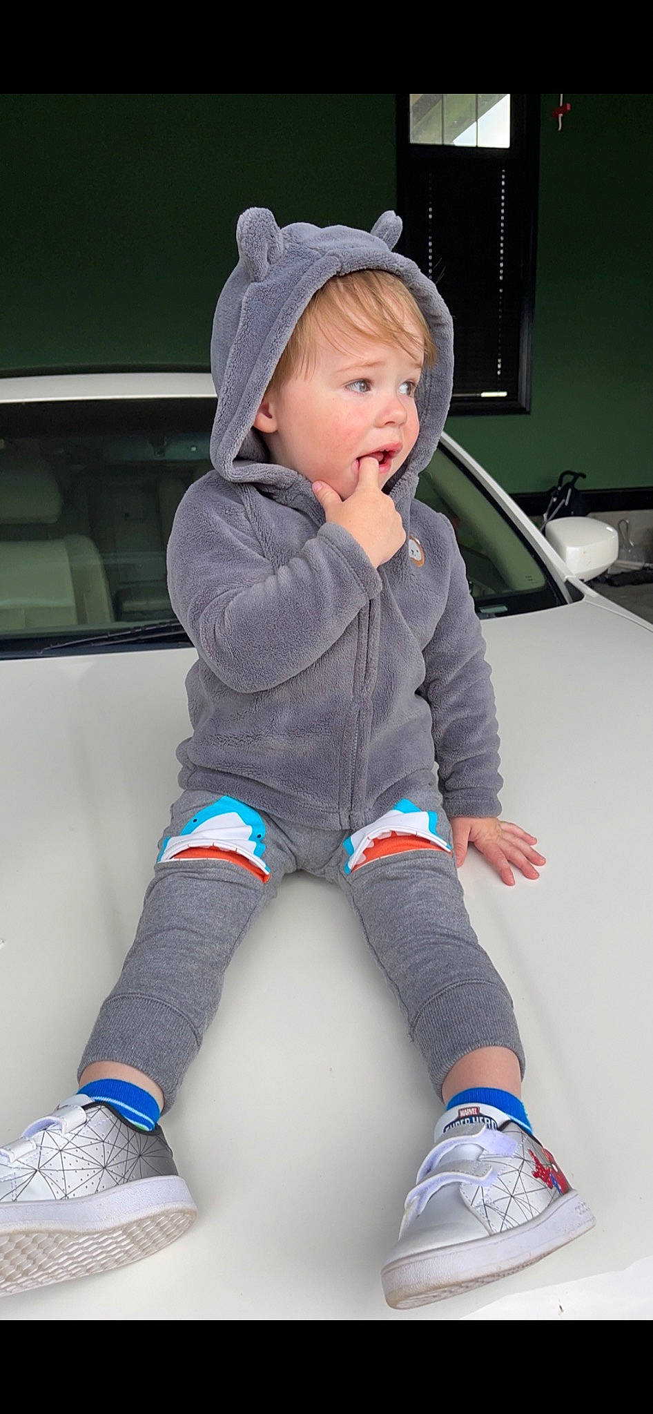 Pierre is registered to the contest to win money with this photo: automotive_design, baby_toddler_clothing, black, blue, child, cool, electric_blue, face, finger, human_leg, joint, knee, leg, person, photograph, sleeve, sock, surprise, thigh, toddler