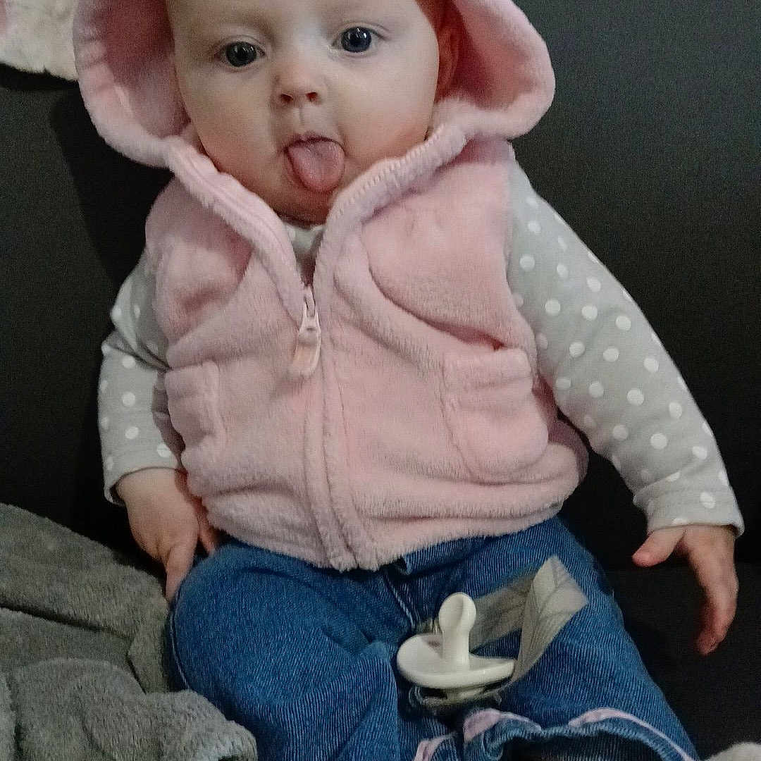 Oaklynn joined the competition — help win amazing prizes! baby, bonnet, clothing, coat, couch, face, furniture, hat, head, hood, hosiery, jacket, jeans, knitwear, pants, person, photography, portrait, sitting, sock