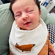Eylan a rejoint le concours — aidez-le/la à gagner de superbes lots ! baby, bib, brown_clothing, cheek, child, closeup, cozy, cushion, cute, face, fox_design, green_cushion, hand, indoor, infant, person, portrait, sleepy, smile, soft_fabric