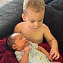 toddler, newborn, baby, child, blanket, couch, indoor, floor, exercise_ball, shirtless, holding, sleeping, family, infant, home, comfort, love, care, together, relaxing