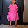 child, smiling, pink_dress, barefoot, standing, indoor, door, floor, marble, happy, person, girl, short_sleeves, young, full_body, portrait, playful, casual, light, home