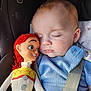Alex is registered to the contest to win money with this photo: baby, toy, woody, doll, sleeping, car_seat, blue_clothing, child, infant, seatbelt, soft_toy, closeup, face, peaceful, childhood, nap, cute, indoor, person, resting