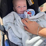 Alex joined the competition — help win amazing prizes! baby, blanket, stroller, hand, rings, bracelet, smile, face, infant, comfort, outdoor, daylight, clothing, person, soft_texture, baby_toy, closeup, resting, cute, peaceful