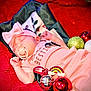 Athena joined the competition — help win amazing prizes! baby, baubles, christmas_ornaments, closeup, cozy, cute, decorations, festive, headband, holiday, indoors, infant, pacifier, peaceful, pink_bow, pink_outfit, rainbow_decor, red_blanket, resting, sleeping