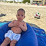 Naël participe au concours pour gagner de l'argent avec cette photo : baby, beach, blue_bean_bag, building, child, happy, infant, outdoor, person, playful, relaxing, sand, shorts, sky, soccer_ball, summer, sunny, tongue_out, towel, vacation