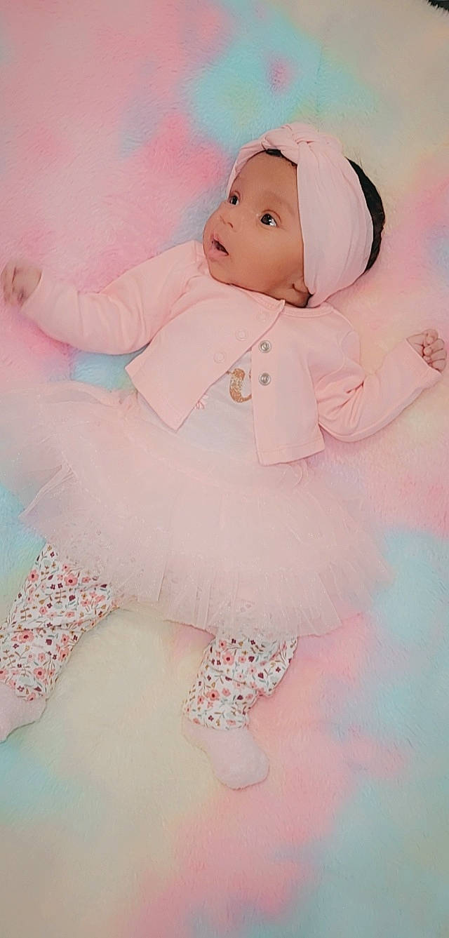 Nyelle is registered to the contest to win money with this photo: baby, baby_products, baby_toddler_clothing, beauty, child, day_dress, happy, headgear, headwear, magenta, pattern, peach, person, photograph, pink, product, sitting, skin, sleeve, smile