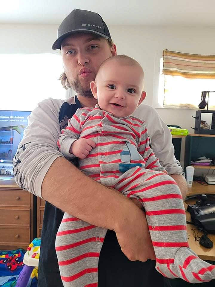 Mason participe au concours pour gagner de l'argent avec cette photo : baseball_cap, cap, child, comfort, curtain, event, facial_expression, fun, happy, headwear, joint, joy, lap, person, plaid, shoulder, sitting, sleeve, smile, standing