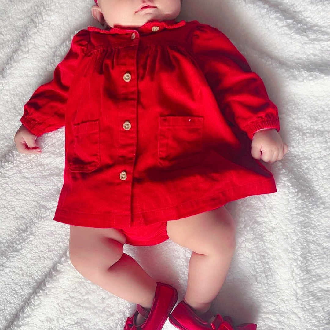 Jannat joined the competition — help win amazing prizes! adorable, baby, blanket, booties, child, clothing, cute, face, fashion, headband, indoor, infant, lying_down, peaceful, portrait, red_dress, small_feet, small_hands, soft_texture, white_background