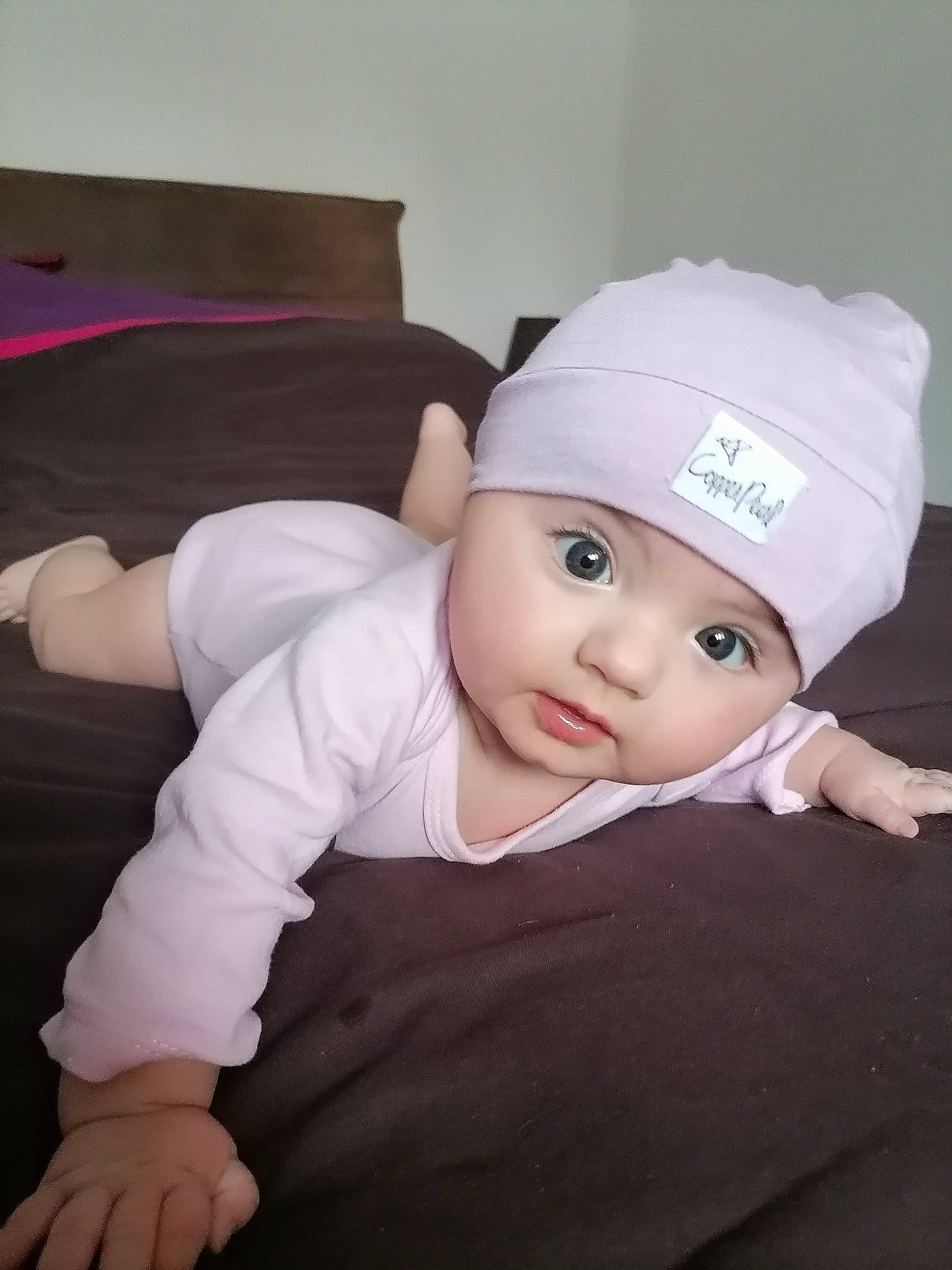 Gloria participe au concours pour gagner de l'argent avec cette photo : baby, baby_toddler_clothing, beanie, cap, cheek, child, comfort, costume_hat, couch, eye, fashion_accessory, flash_photography, fun, hat, headwear, person, personal_protective_equipment, pillow, sitting, sleeve